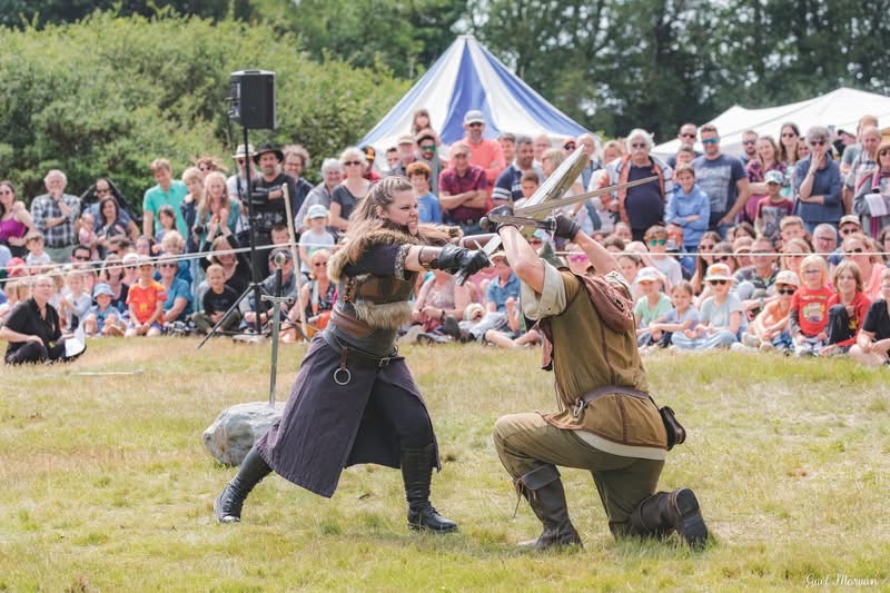 The Sherwood Outlaws performing a live medieval sword fight in front of a seated crowd at the Keyworth Show